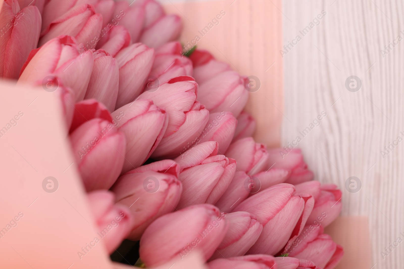 Photo of Bouquet of beautiful pink tulips on white wooden table, above view