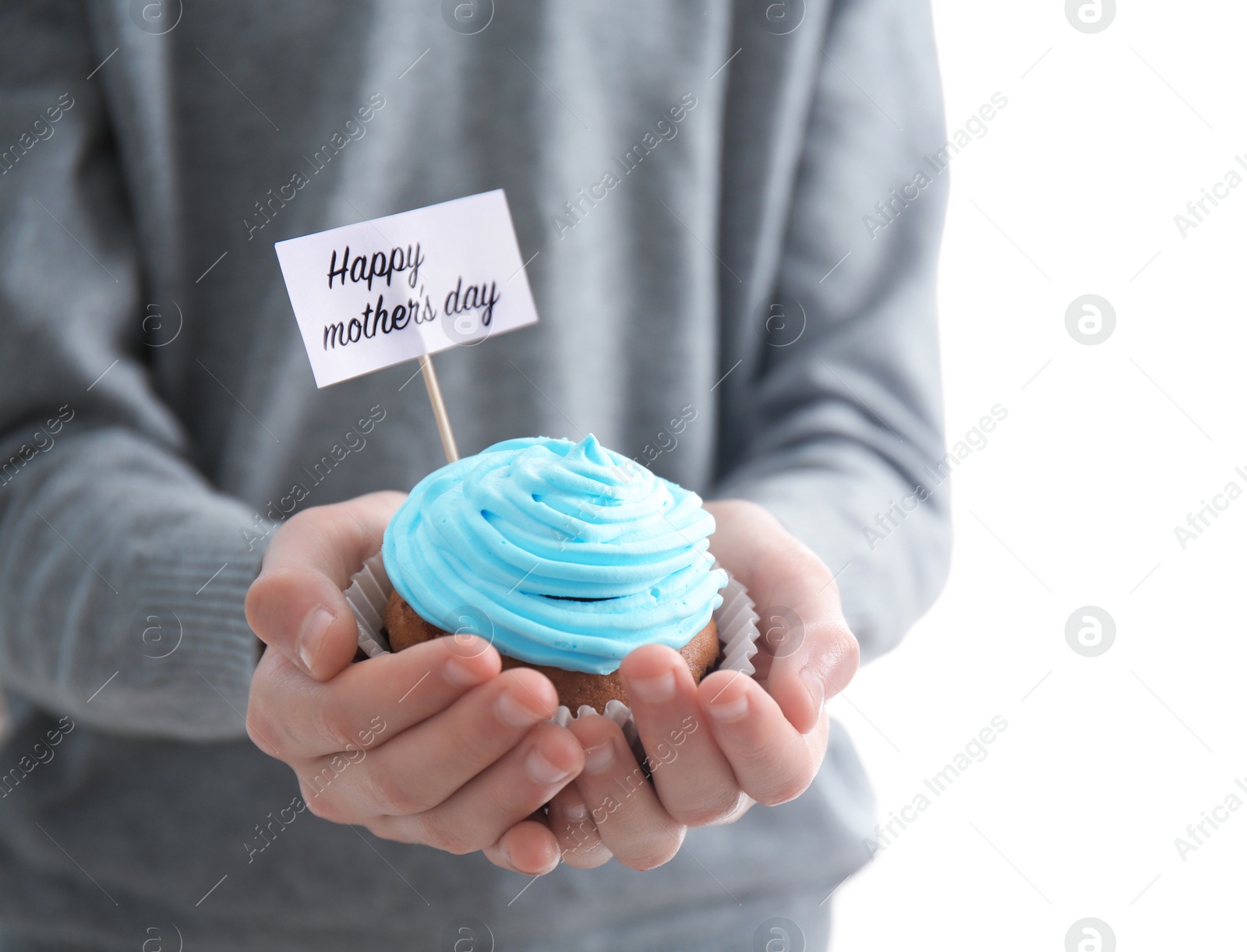 Photo of Little child holding tasty cupcake for Mother's Day, closeup