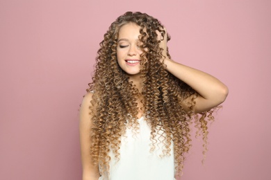 Portrait of beautiful young woman with shiny wavy hair on color background