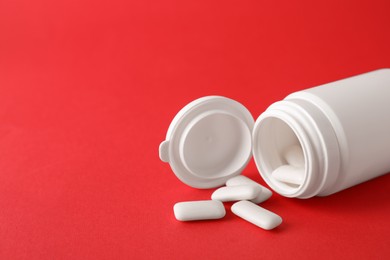 Photo of Jar with chewing gums on red background