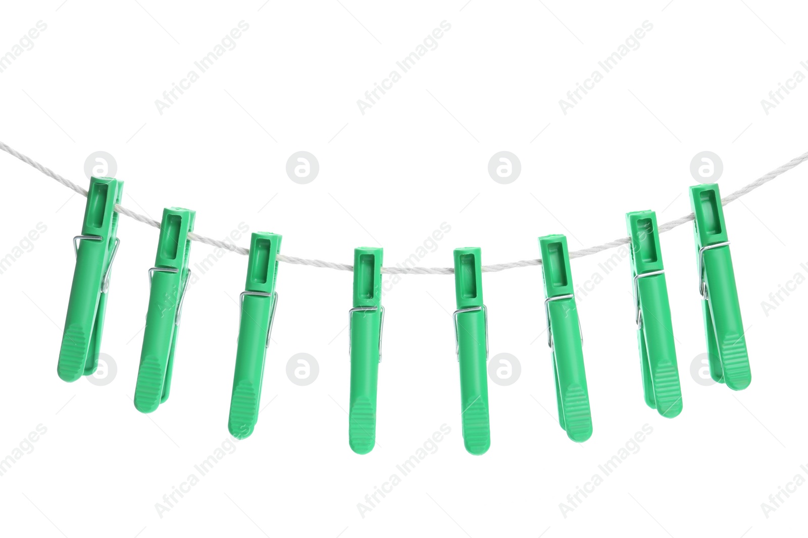 Photo of Green plastic clothespins hanging on rope against white background