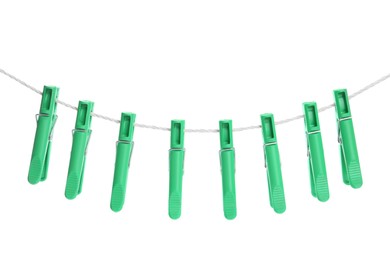 Green plastic clothespins hanging on rope against white background