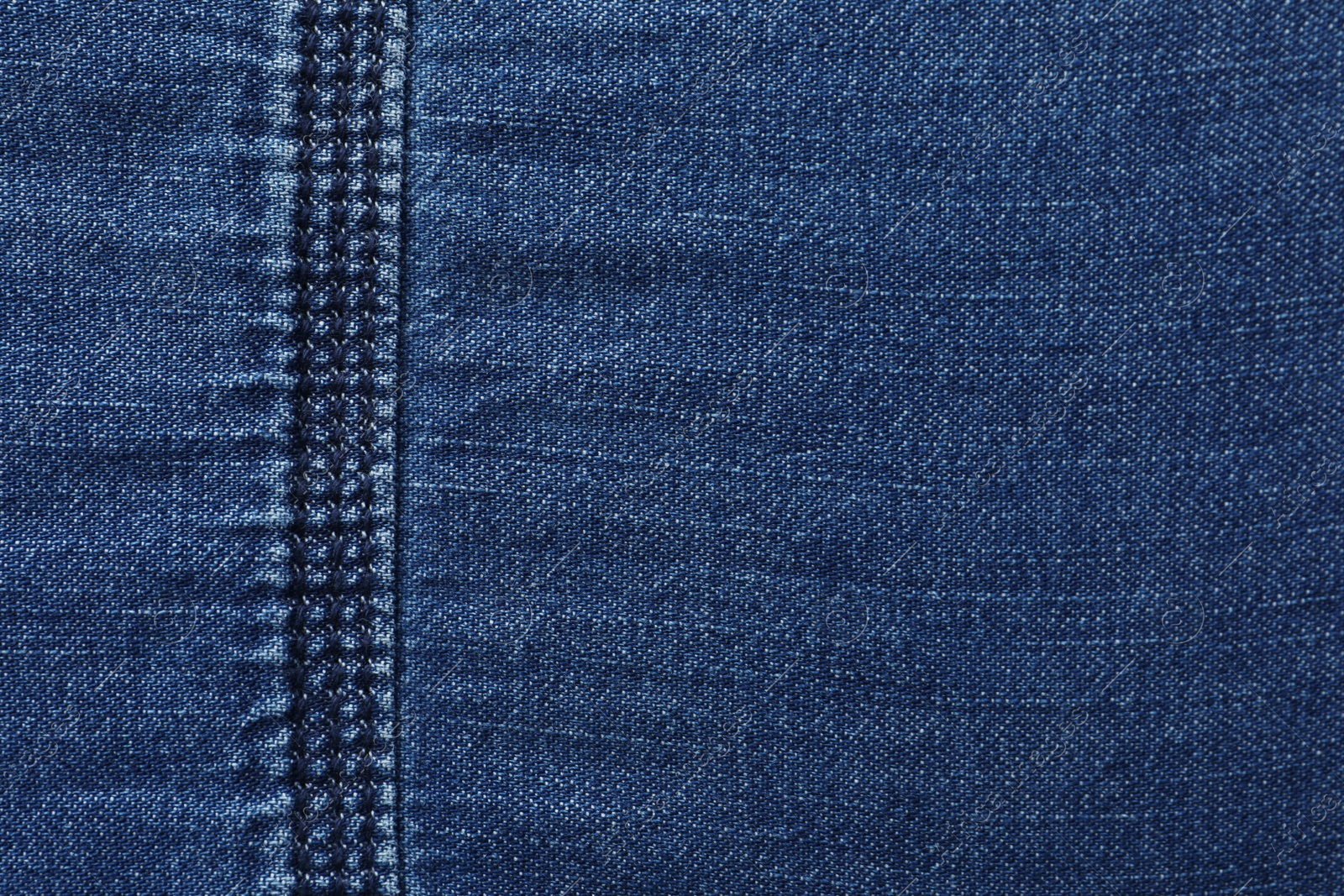 Photo of Texture of dark blue jeans as background, closeup