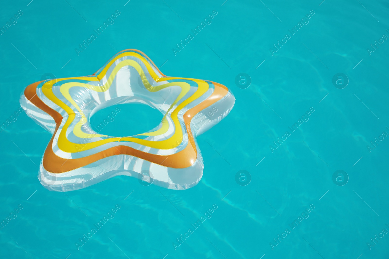 Photo of Star shaped inflatable ring floating in swimming pool on sunny day. Space for text