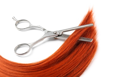 Photo of Red hair and thinning scissors on white background. Hairdresser service