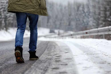 Photo of Man walking outdoors on snowy winter day. Space for text