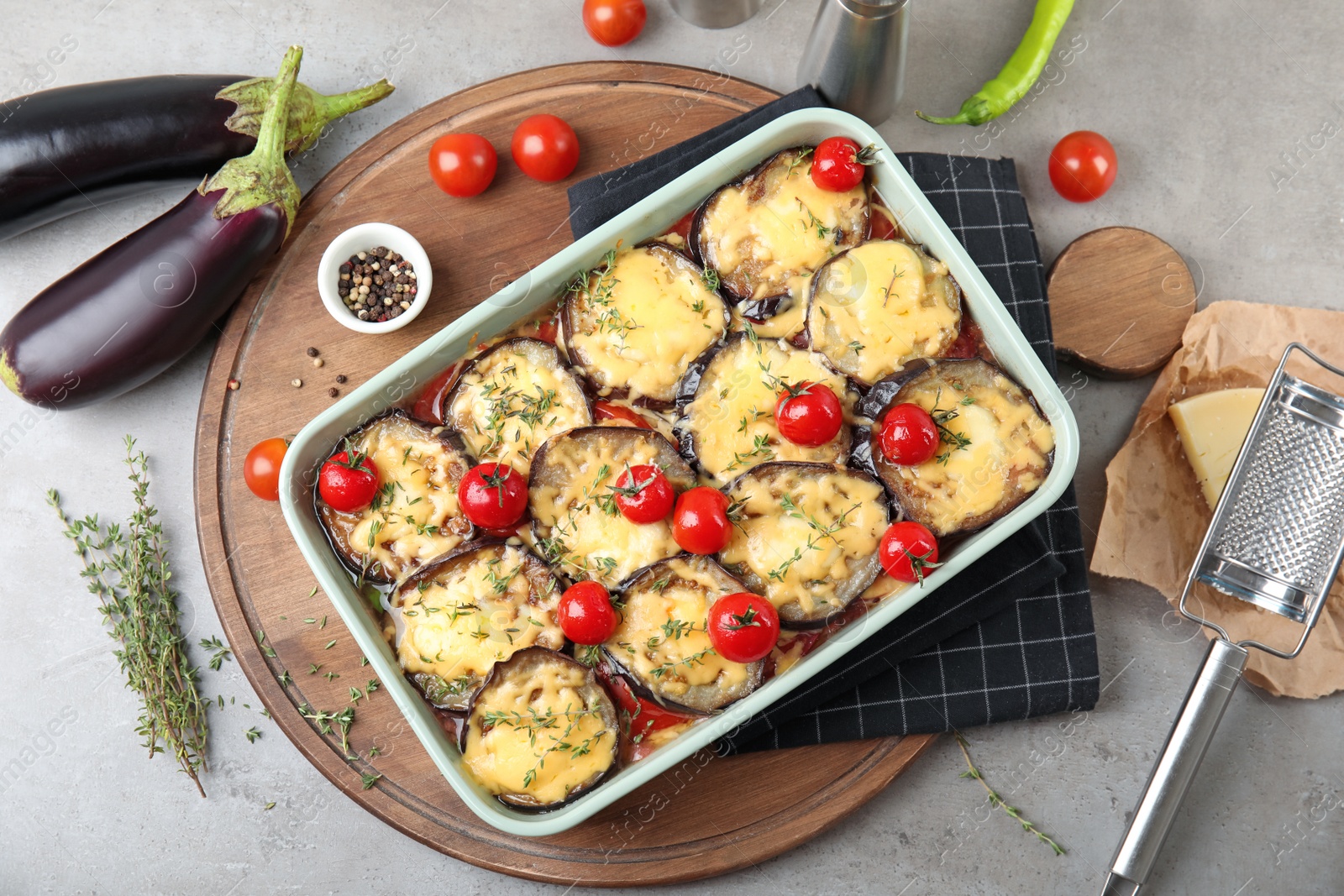 Photo of Flat lay composition with baked eggplant, tomatoes and cheese in dishware on table