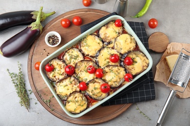 Photo of Flat lay composition with baked eggplant, tomatoes and cheese in dishware on table