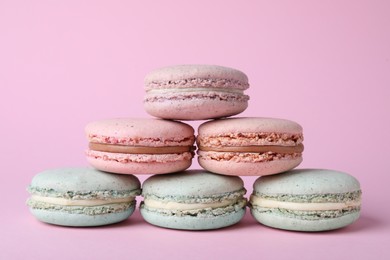 Pile of delicious colorful macarons on pink background