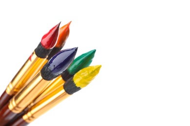 Brushes with colorful paints on white background