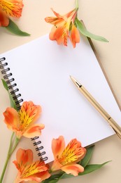 Guest list. Notebook, pen and beautiful flowers on beige background, flat lay. Space for text