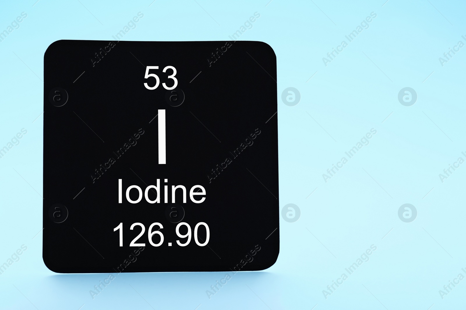 Photo of Card with iodine element on light blue background. Space for text