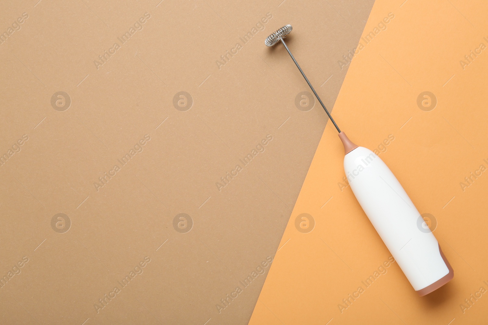 Photo of White milk frother wand on color background, top view. Space for text