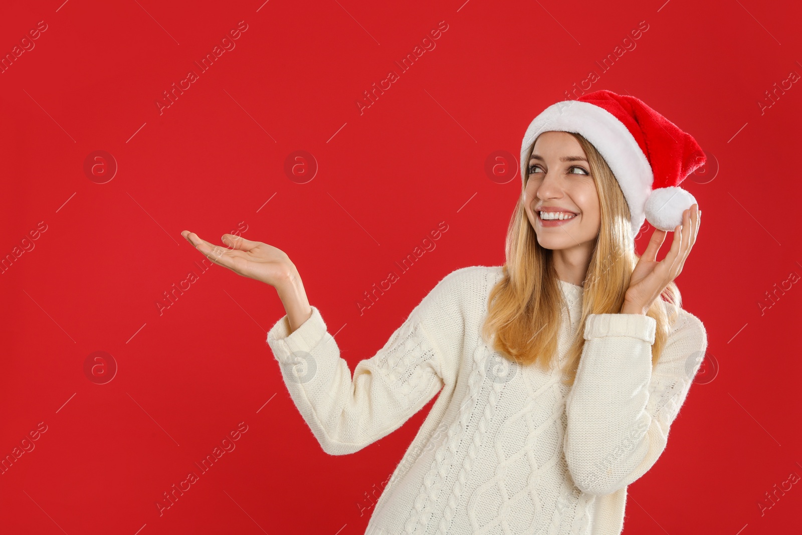 Photo of Happy woman in Santa hat on red background. Christmas countdown