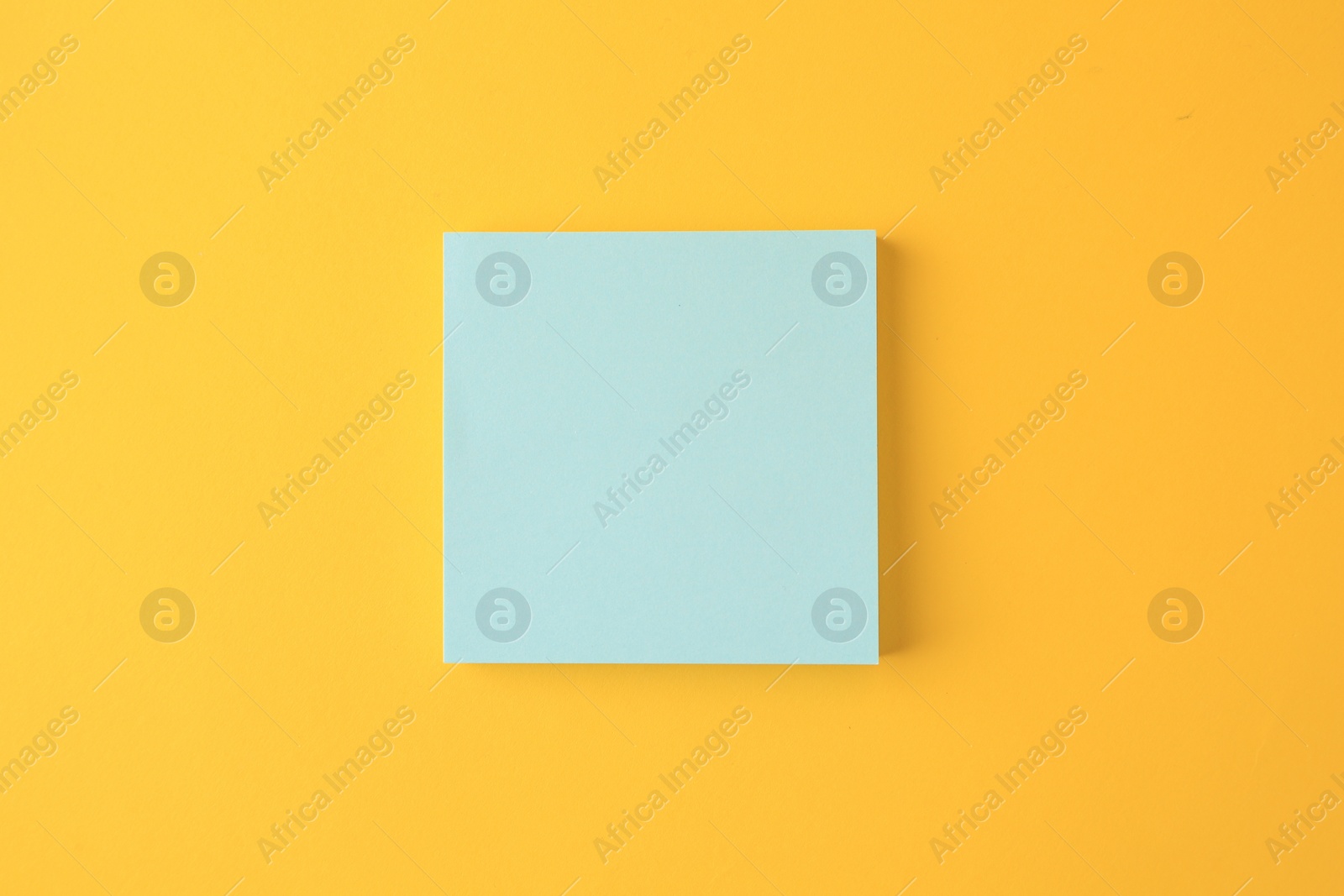 Photo of Blank paper note on orange background, top view