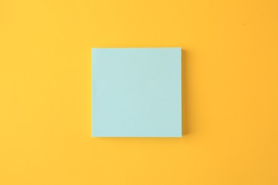 Photo of Blank paper note on orange background, top view