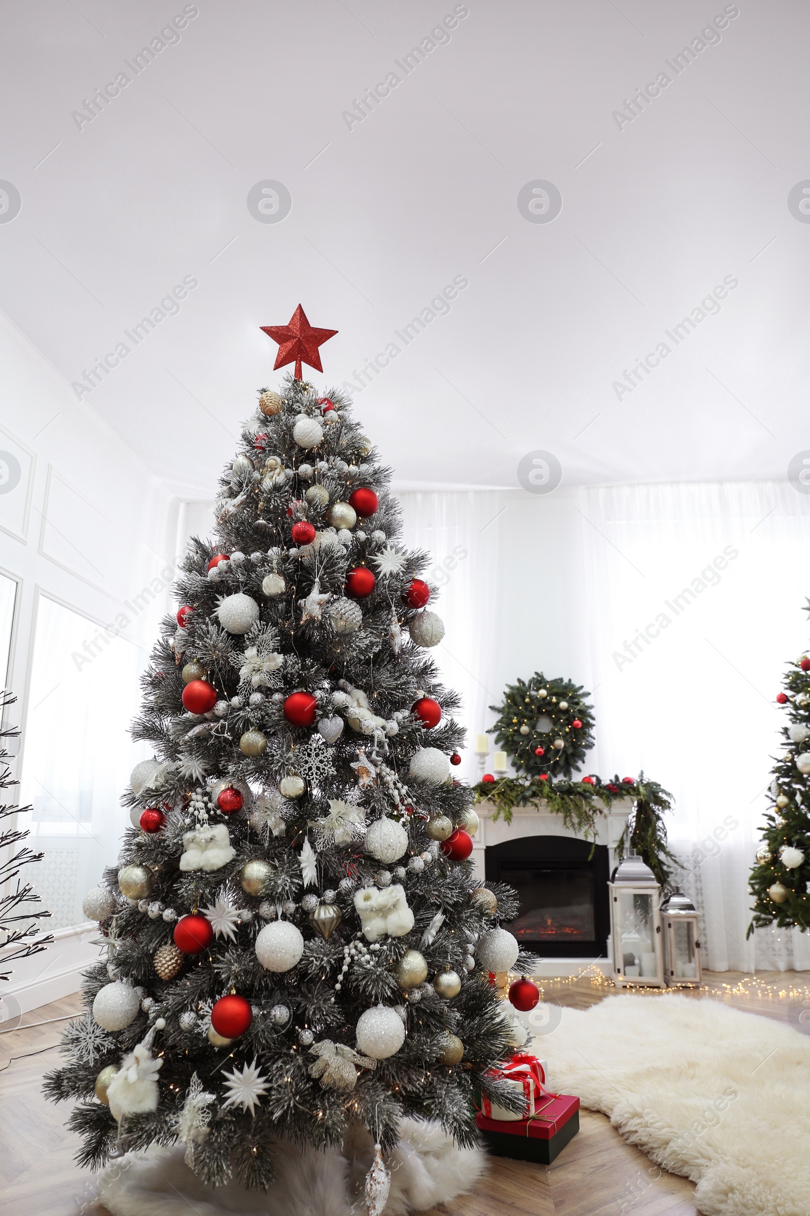 Photo of Beautiful Christmas tree with star topper in decorated room