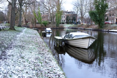 Photo of Picturesque view of water canal with moored boats on winter day