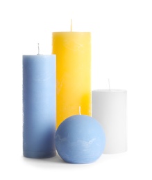 Photo of New wax candles of different shapes on white background