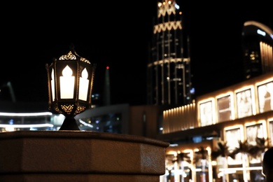 Photo of DUBAI, UNITED ARAB EMIRATES - NOVEMBER 04, 2018: Street lantern against blurred cityscape, space for text