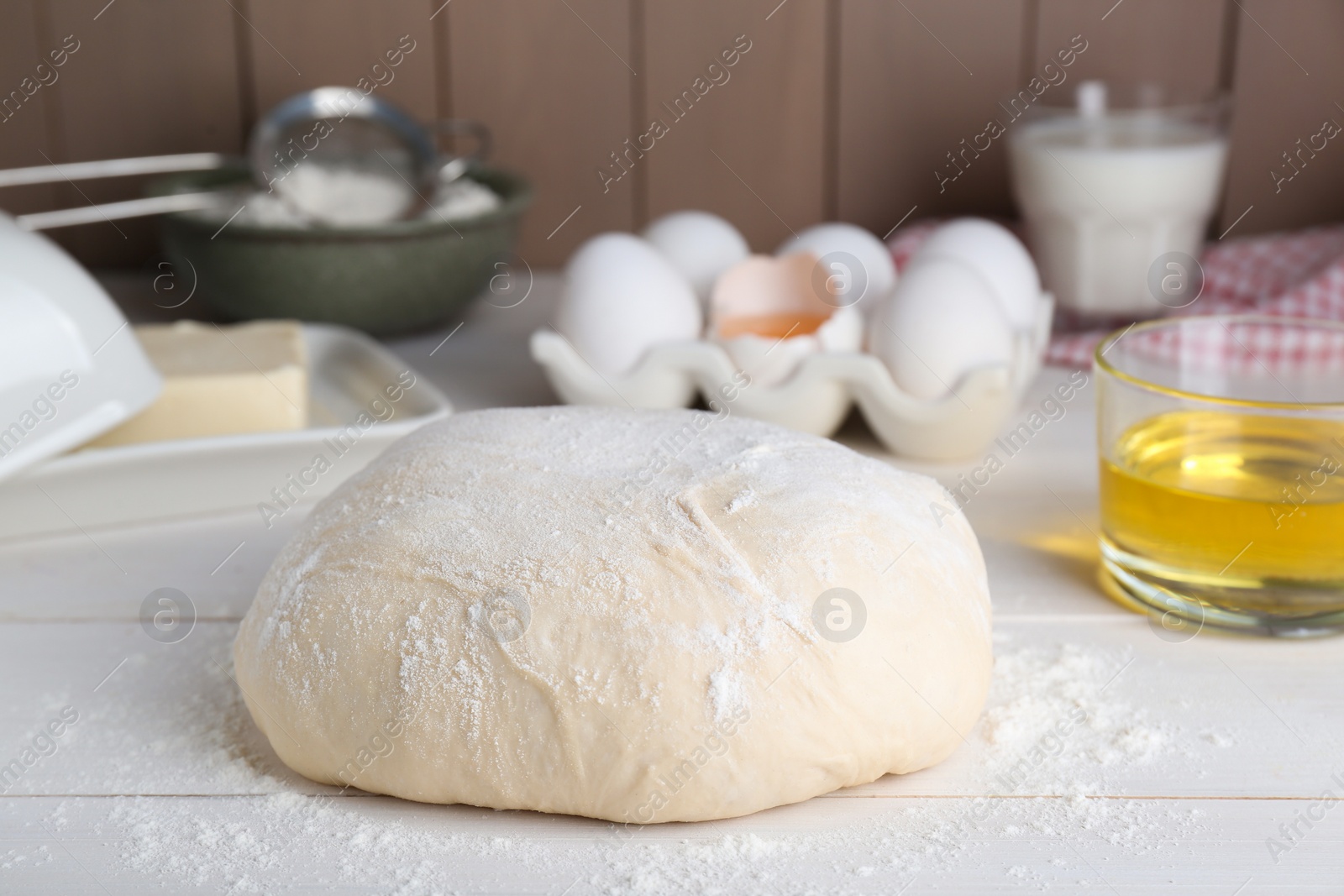 Photo of Fresh yeast dough and ingredients on white wooden table