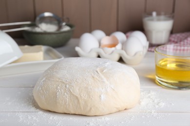 Photo of Fresh yeast dough and ingredients on white wooden table