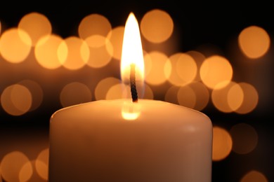 Photo of Burning candle in darkness, closeup. Memory day