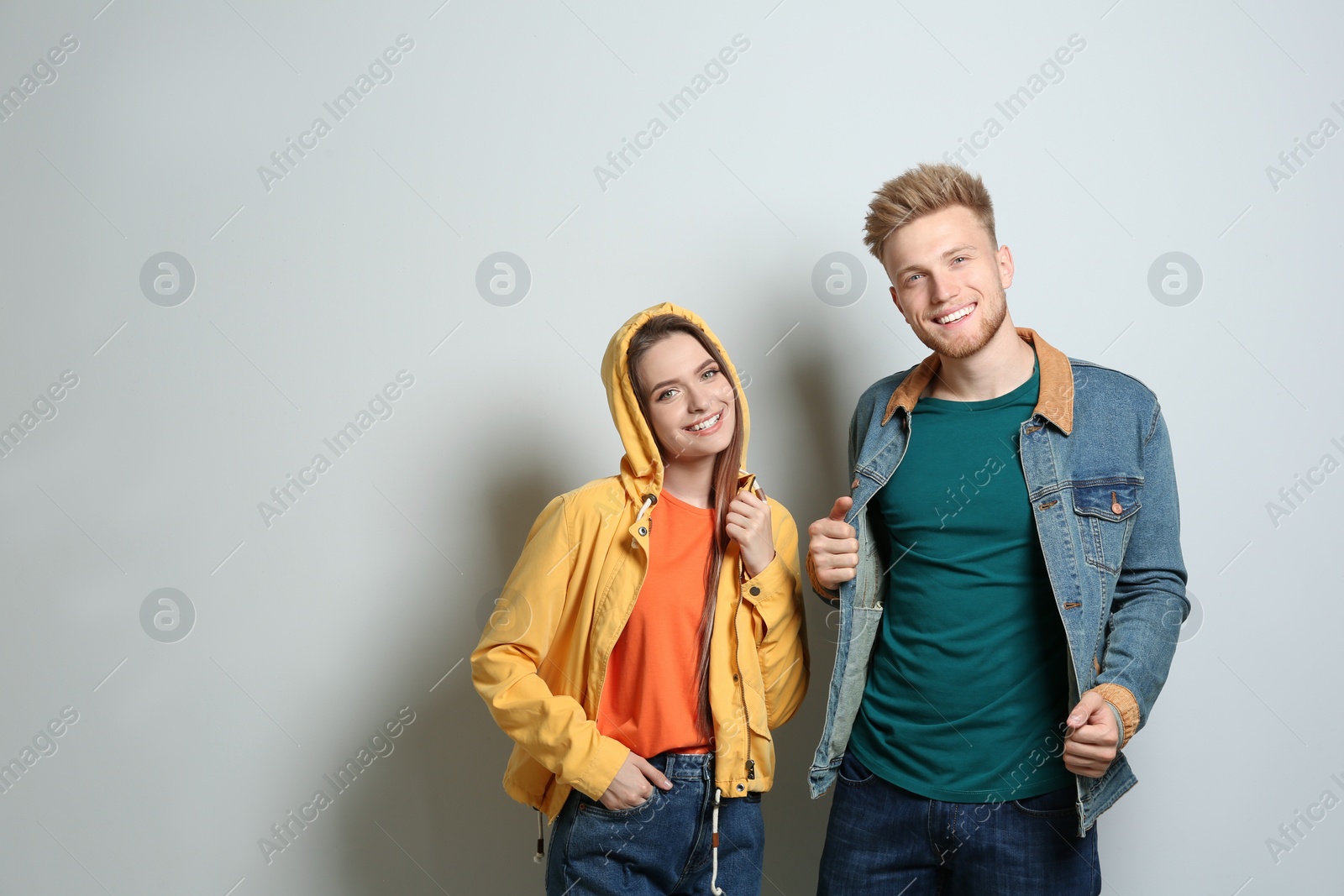 Photo of Young couple wearing blank t-shirts on light background. Mockup for design