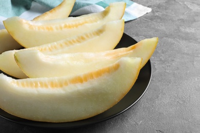 Photo of Slices of delicious honey melon on black table