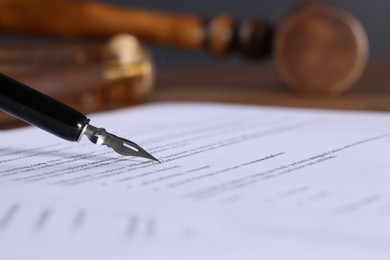 Photo of Writing on document with fountain pen at table, closeup and space for text. Notary contract