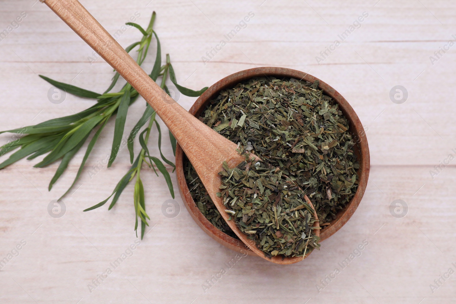 Photo of Dry and fresh tarragon on wooden table, flat lay