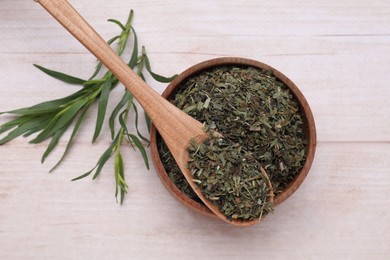 Dry and fresh tarragon on wooden table, flat lay