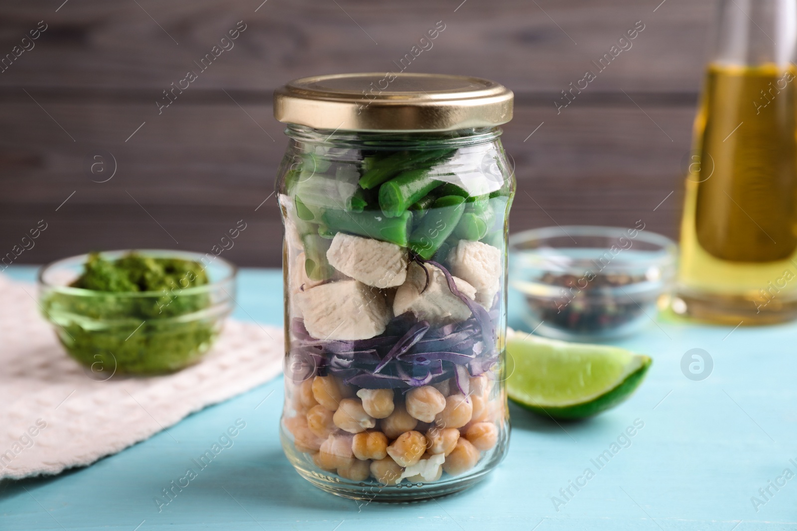 Photo of Glass jar with healthy meal on light blue wooden table