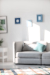 Photo of Blurred view of stylish living room interior with comfortable sofa