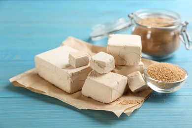 Compressed and granulated yeast on light blue wooden table