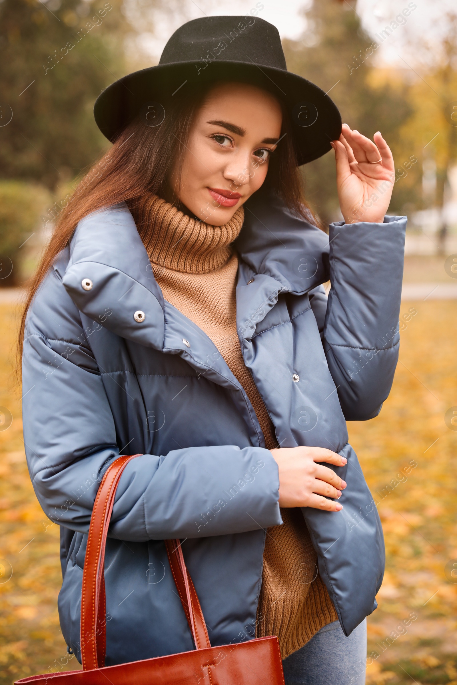 Photo of Young woman wearing stylish clothes in autumn park