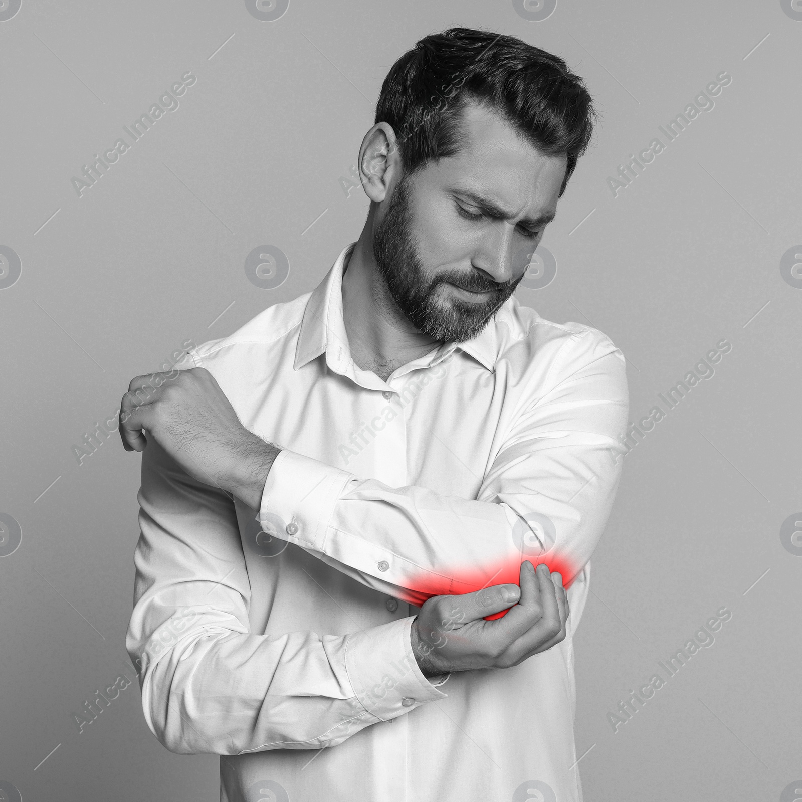 Image of Man suffering from rheumatism on light background. Black and white effect with red accent in painful area