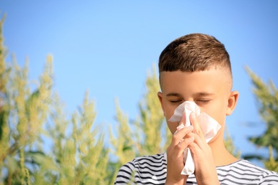 Little boy suffering from ragweed allergy outdoors