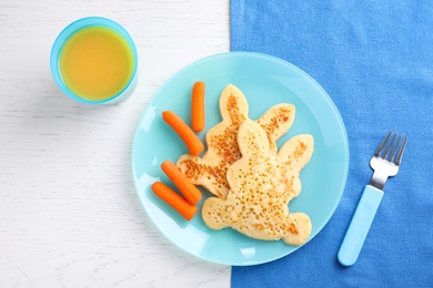 Photo of Tasty bunny shaped pancakes served with carrots and juice on white wooden table, flat lay. Creative idea for kids breakfast