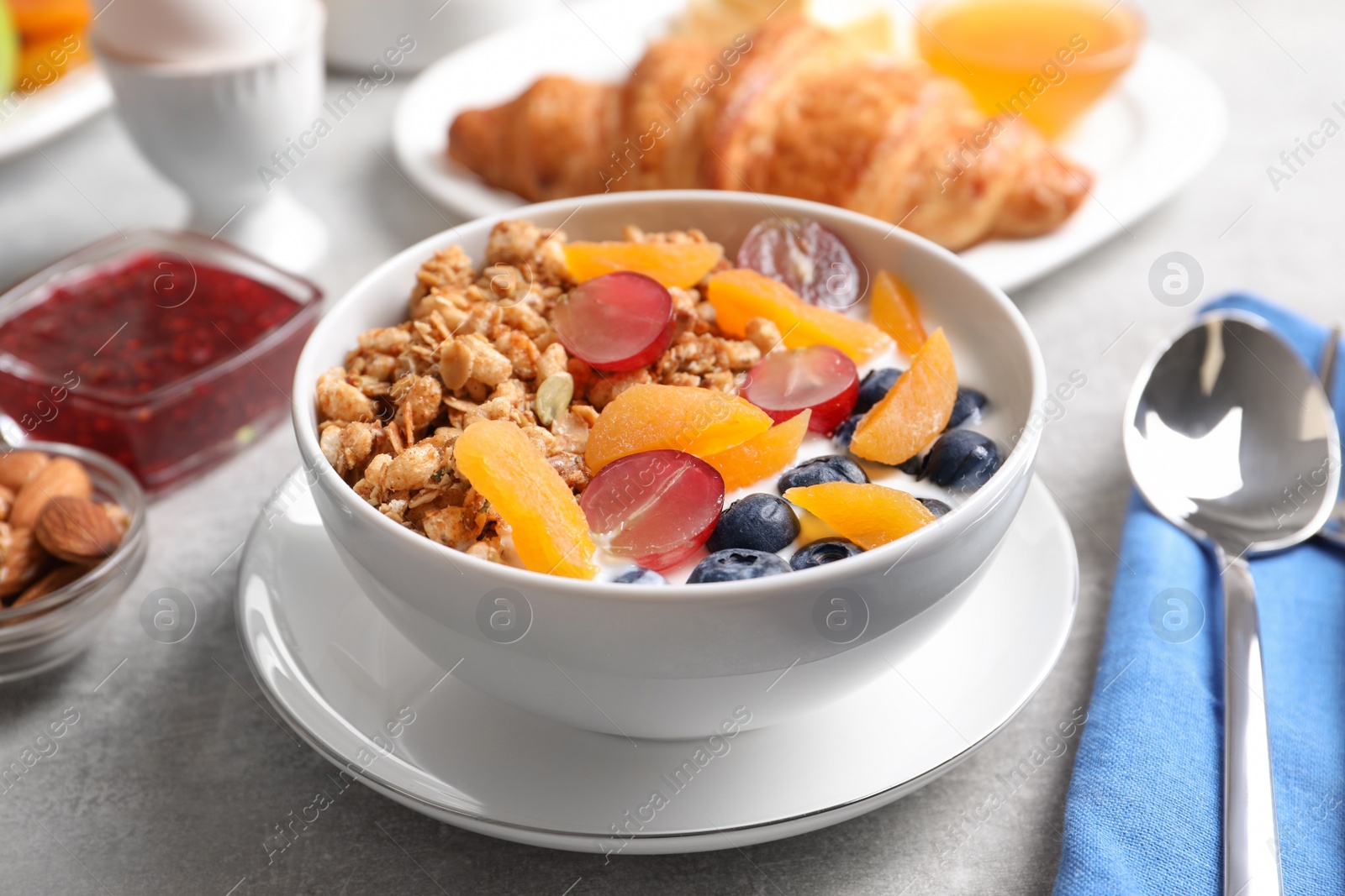 Photo of Delicious granola with fruits served on white table