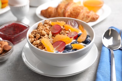 Photo of Delicious granola with fruits served on white table