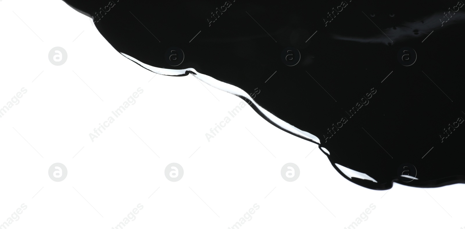 Photo of Black glossy paint spilled on white background