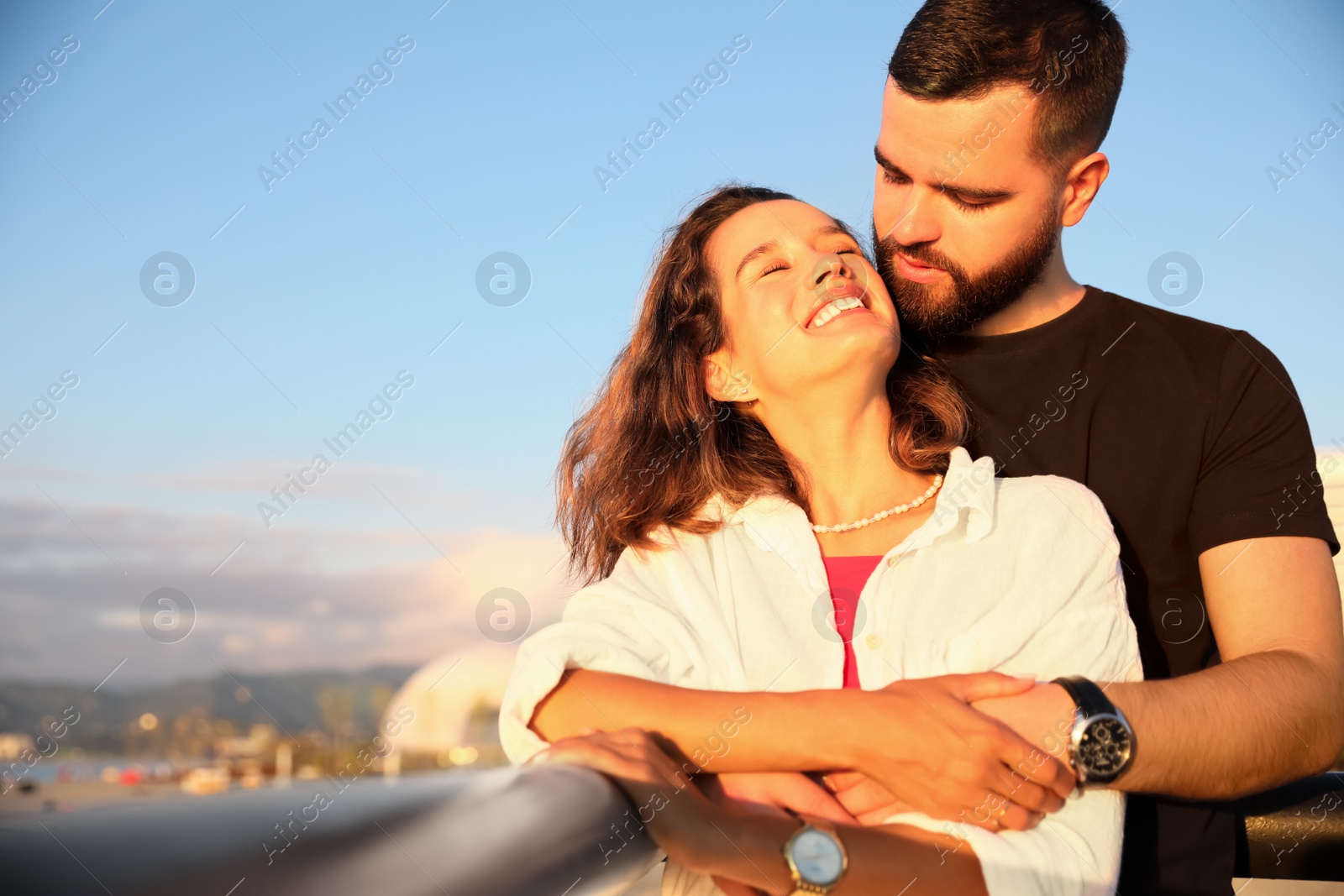 Photo of Happy young couple hugging on sea embankment