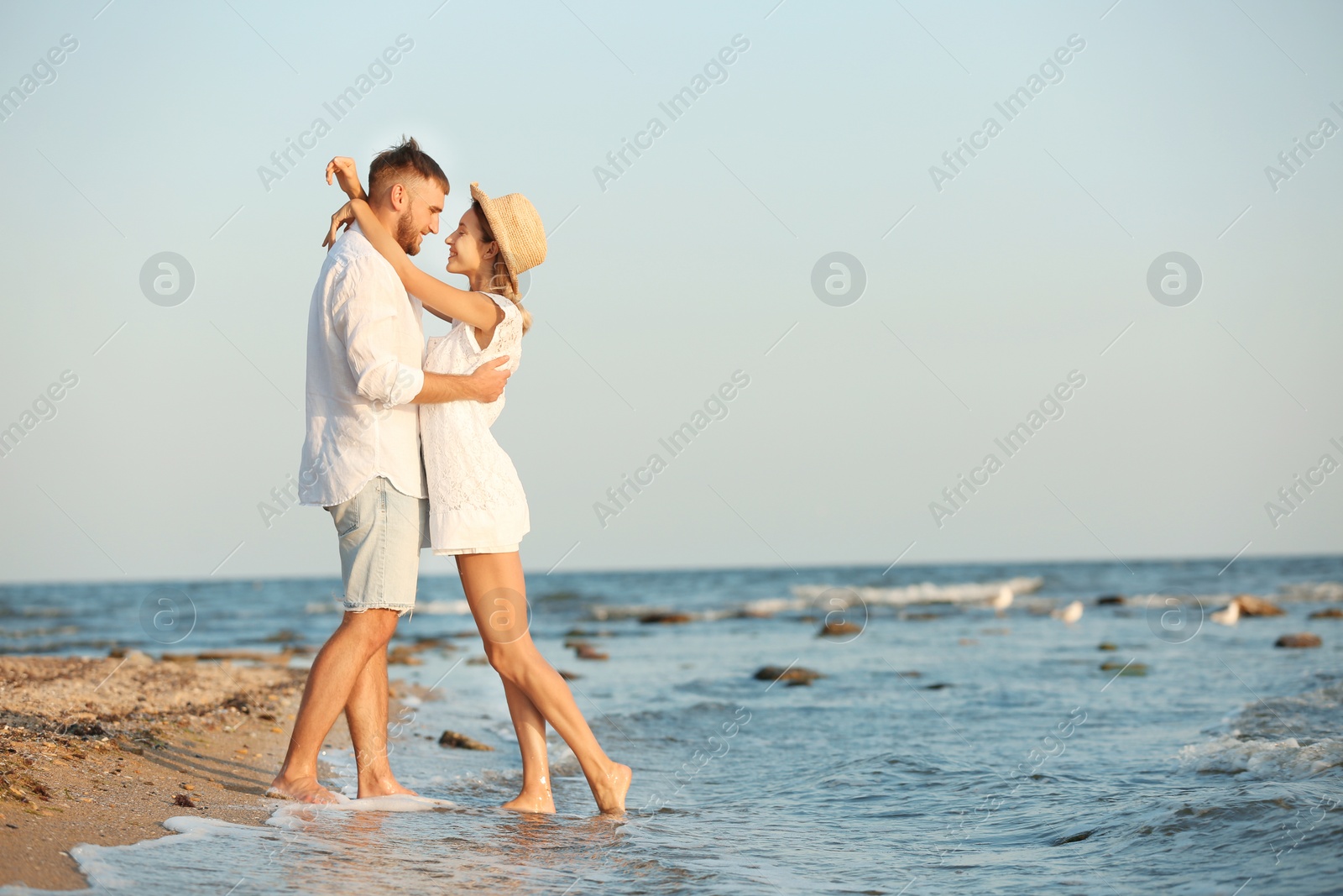 Photo of Young couple spending time together on beach