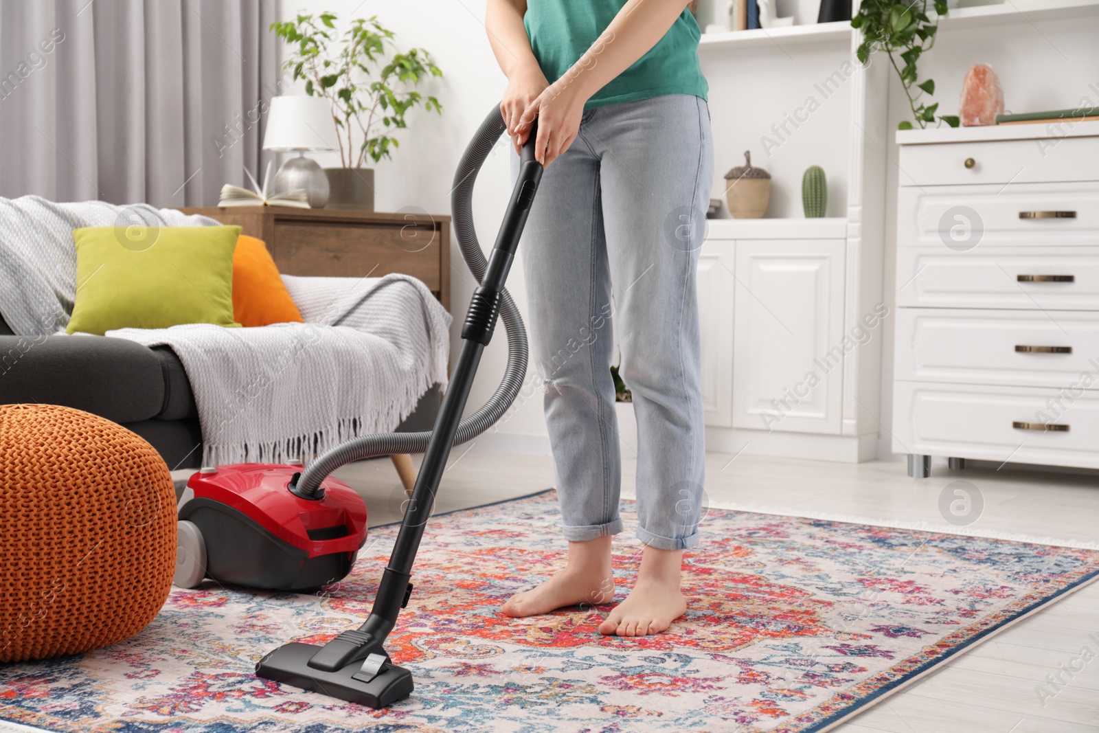 Photo of Woman cleaning carpet with vacuum cleaner at home, closeup