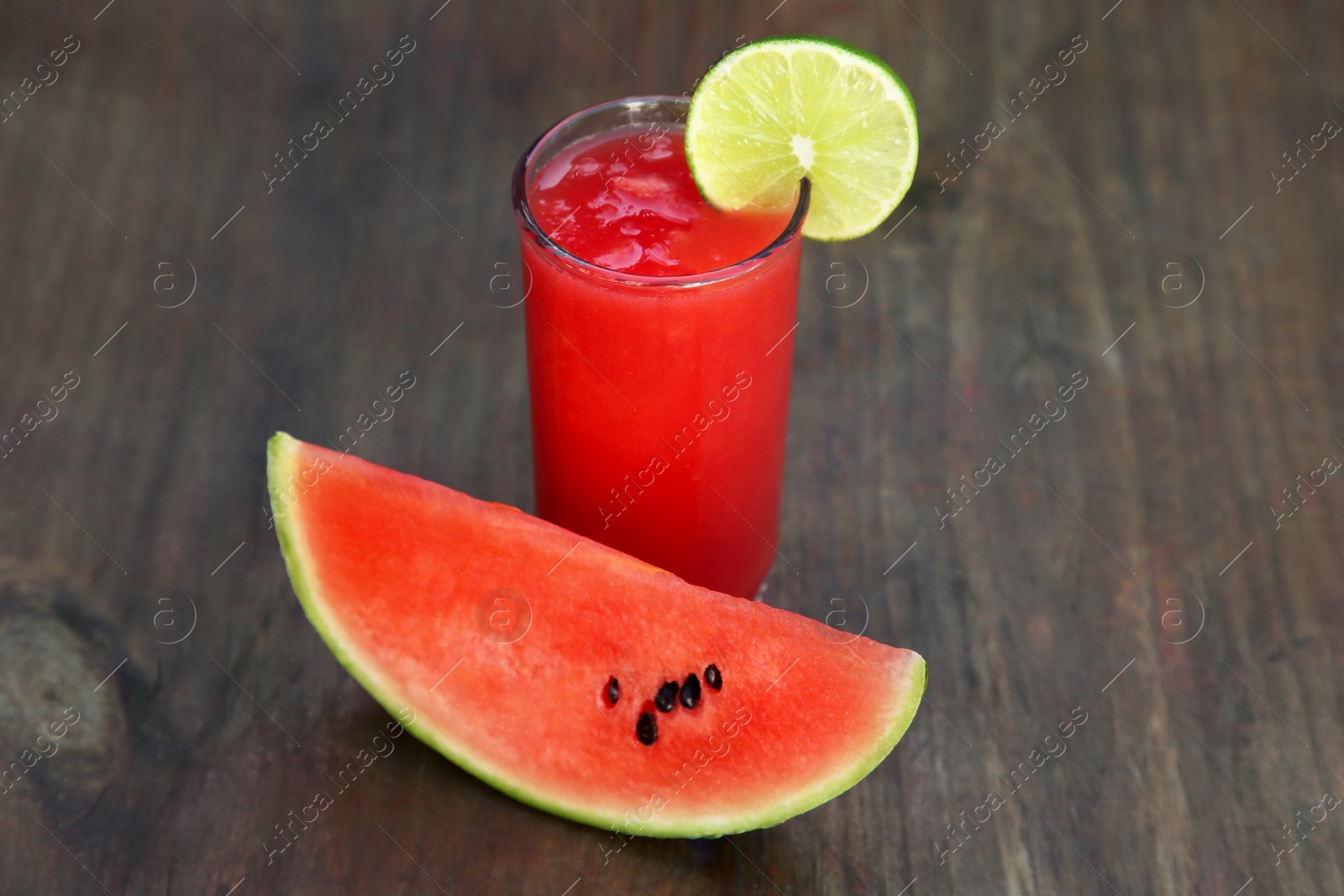 Photo of Delicious watermelon drink in glass on wooden table