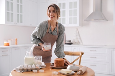 Young woman making traditional Easter cake in kitchen