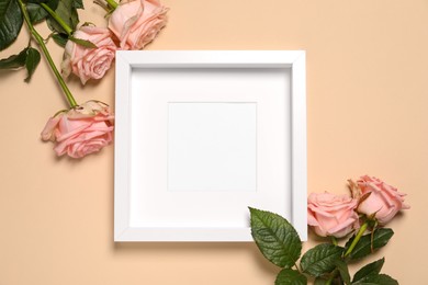 Photo of Empty photo frame and beautiful flowers on beige background, flat lay. Space for design