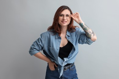 Portrait of beautiful tattooed woman on gray background