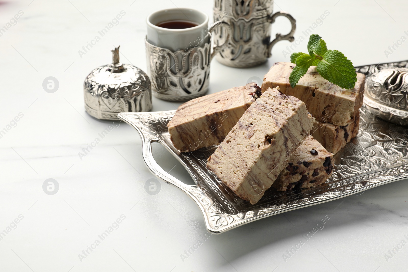 Photo of Tasty chocolate halva served on white marble table. Space for text